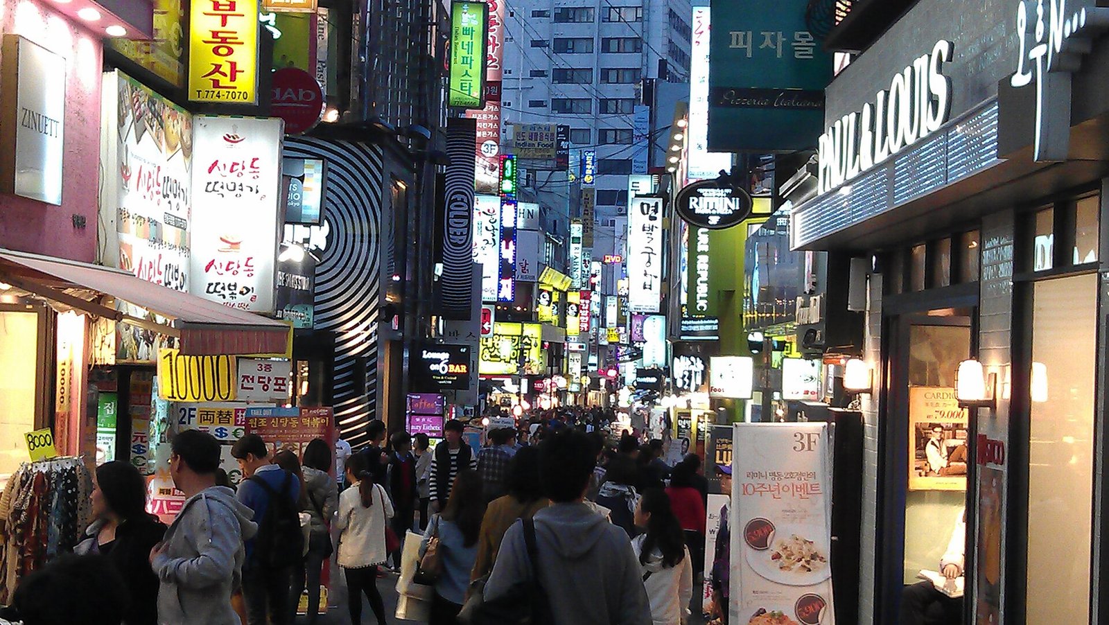 Myeongdong shopping street in Seoul at night with neon Korean signs